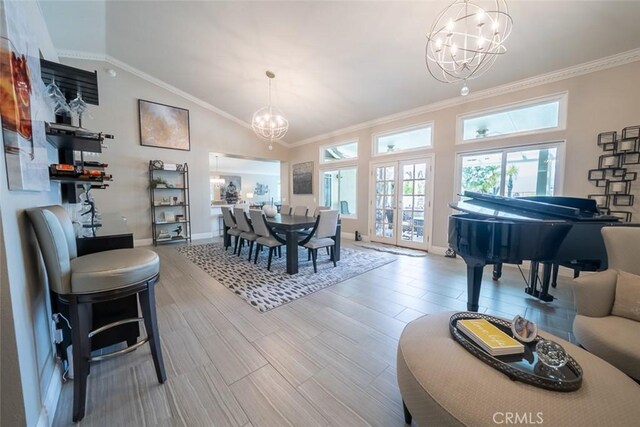 dining area featuring baseboards, a notable chandelier, ornamental molding, and lofted ceiling