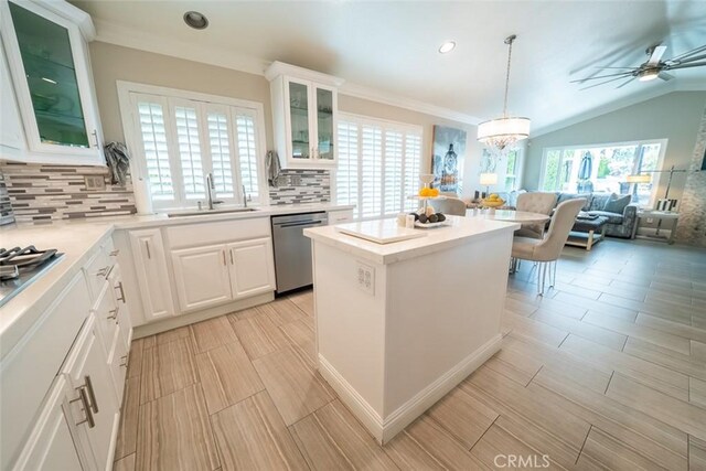 kitchen featuring a kitchen island, tasteful backsplash, a sink, open floor plan, and stainless steel appliances