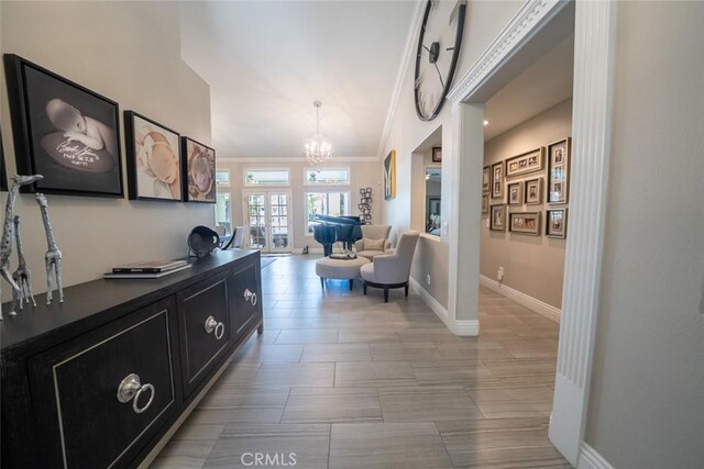 hall featuring baseboards, a notable chandelier, and ornamental molding