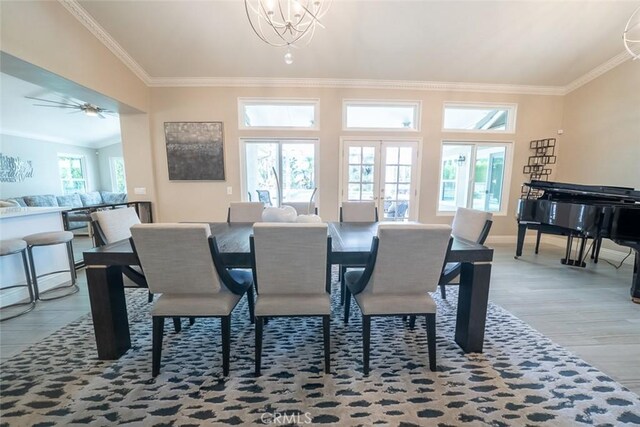 dining area featuring crown molding, baseboards, wood finished floors, and a notable chandelier
