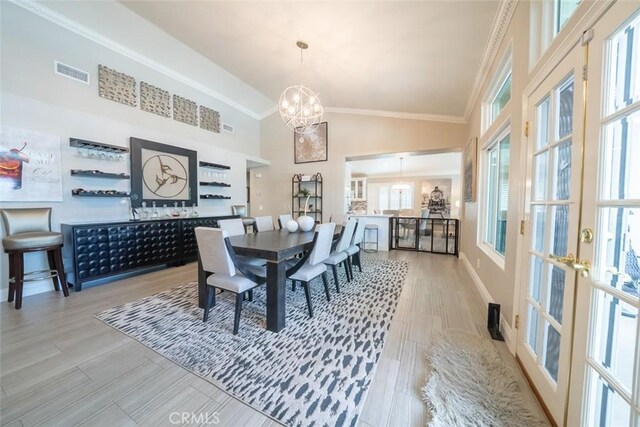 dining room with crown molding, a notable chandelier, high vaulted ceiling, french doors, and visible vents