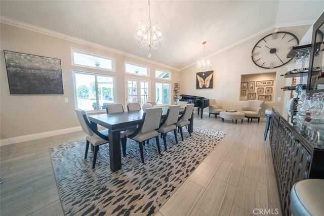 dining room with baseboards, crown molding, a notable chandelier, and high vaulted ceiling