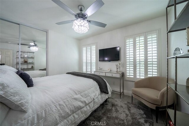 bedroom featuring a ceiling fan, baseboards, and wood finished floors