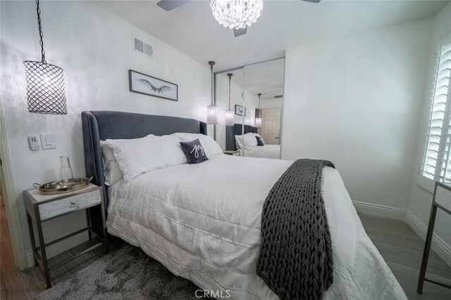bedroom featuring baseboards, visible vents, and wood finished floors