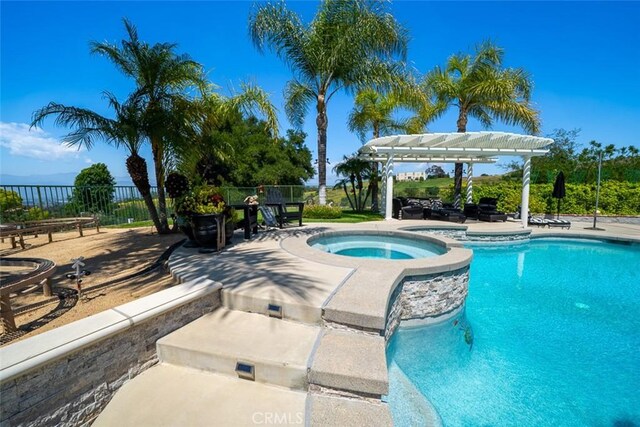 view of pool with a pergola, a pool with connected hot tub, fence, and a patio