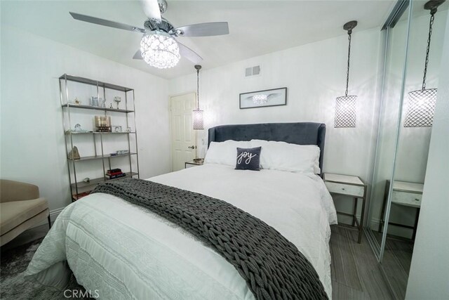 bedroom with visible vents, a ceiling fan, and wood finished floors