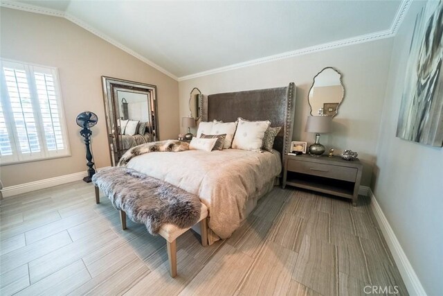 bedroom featuring baseboards, vaulted ceiling, and ornamental molding