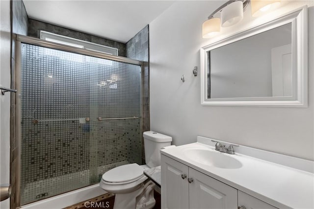 full bathroom with a stall shower, toilet, and vanity