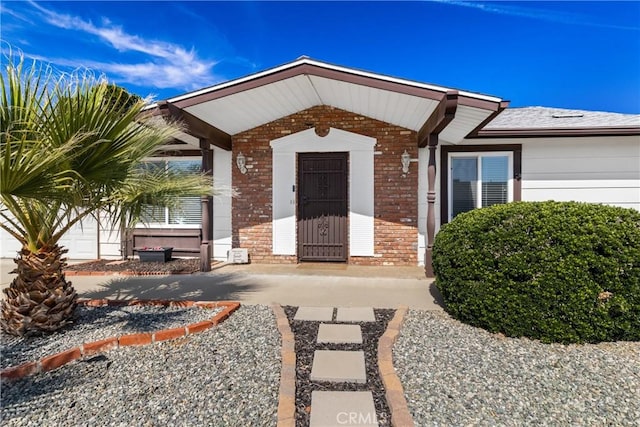 view of exterior entry with brick siding
