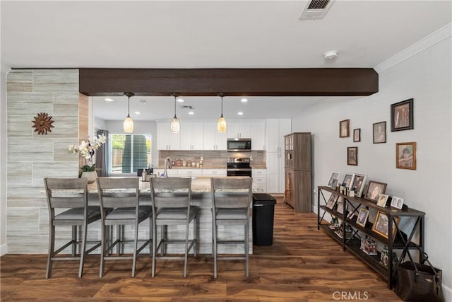 27680 Sandtrap Dr, Menifee, CA 92586 - kitchen with appliances with stainless steel finishes, a kitchen breakfast bar, white cabinets, tasteful backsplash, and dark wood-style floors