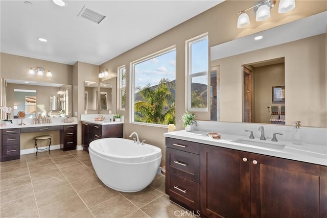 21609 Lucas Ct, Saugus, CA 91390 - bathroom with visible vents, a freestanding tub, two vanities, a sink, and tile patterned floors