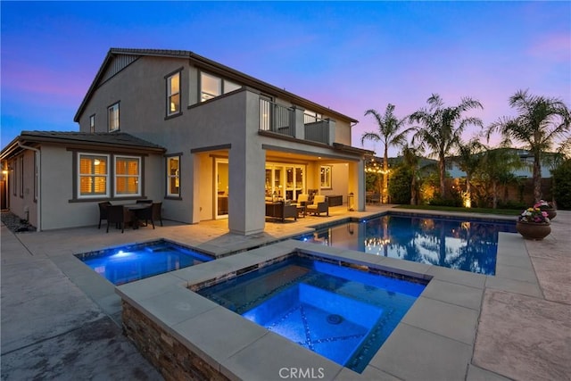 21609 Lucas Ct, Saugus, CA 91390 - back of house at dusk with an in ground hot tub, a balcony, a patio area, and an outdoor pool