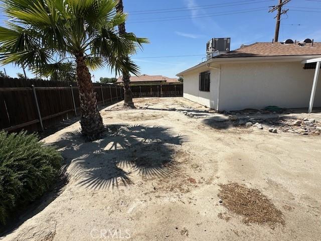 view of yard featuring fence and central AC unit