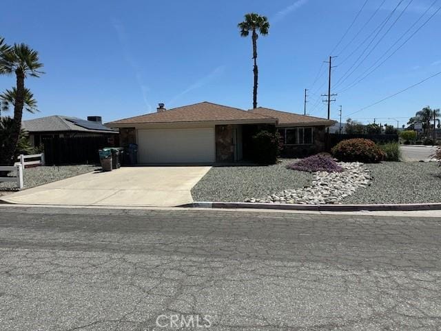 single story home with driveway, fence, and an attached garage