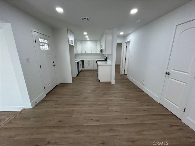 kitchen featuring white cabinetry, visible vents, light countertops, recessed lighting, and wood finished floors