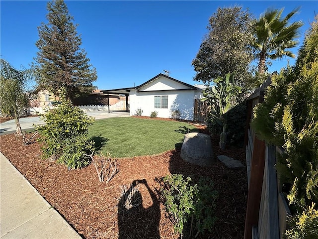 exterior space with a front lawn, stucco siding, and fence
