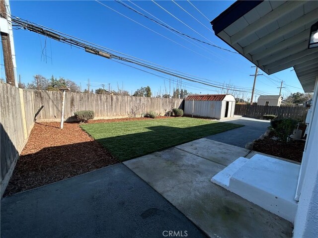 view of yard featuring an outdoor structure, a patio, a shed, and a fenced backyard