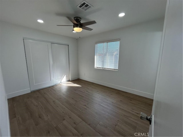 unfurnished bedroom with recessed lighting, a closet, visible vents, baseboards, and wood finished floors