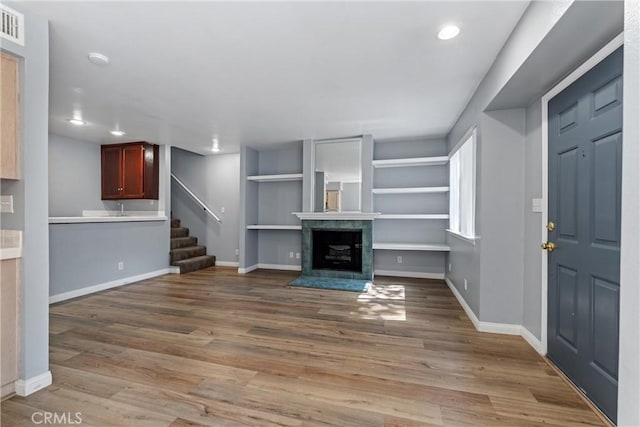 43445 30th St W Unit 2, Lancaster, CA 93536 - unfurnished living room with recessed lighting, wood finished floors, stairway, a tile fireplace, and baseboards