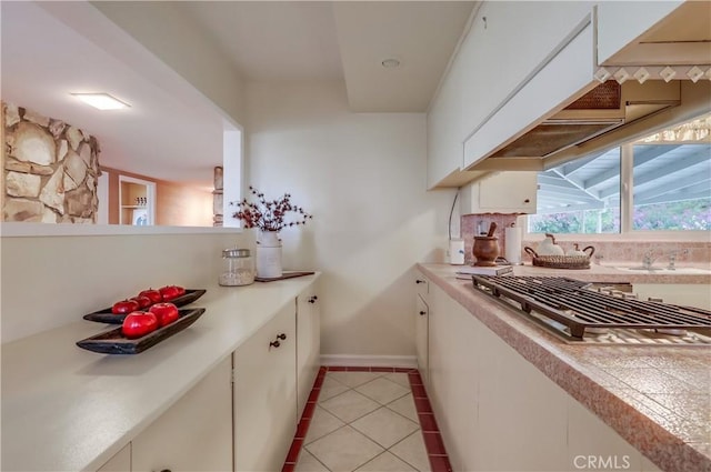 2978 Crownview Dr, Rancho Palos Verdes, CA 90275 - kitchen with light countertops, light tile patterned flooring, stainless steel gas stovetop, white cabinetry, and tasteful backsplash