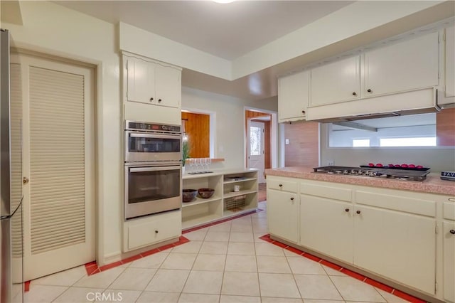 2978 Crownview Dr, Rancho Palos Verdes, CA 90275 - kitchen with stainless steel appliances, light countertops, light tile patterned floors, under cabinet range hood, and white cabinetry