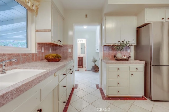 2978 Crownview Dr, Rancho Palos Verdes, CA 90275 - kitchen with freestanding refrigerator, light countertops, decorative backsplash, light tile patterned flooring, and white cabinets
