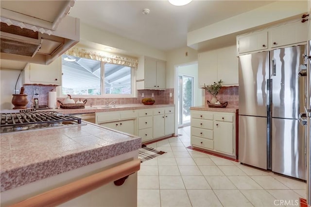 2978 Crownview Dr, Rancho Palos Verdes, CA 90275 - kitchen with appliances with stainless steel finishes, backsplash, extractor fan, white cabinets, and light tile patterned floors