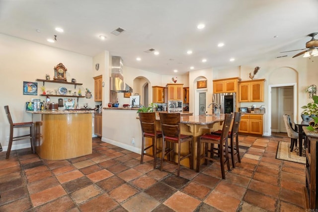 25444 Rancho Barona Rd, Ramona, CA 92065 - kitchen with wall chimney range hood, appliances with stainless steel finishes, a breakfast bar, a peninsula, and recessed lighting