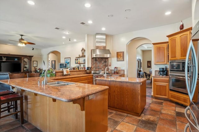 25444 Rancho Barona Rd, Ramona, CA 92065 - kitchen featuring a large island, wall chimney range hood, a sink, stainless steel appliances, and ceiling fan