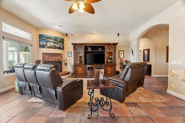 25444 Rancho Barona Rd, Ramona, CA 92065 - living area featuring a ceiling fan, baseboards, a fireplace, arched walkways, and stone tile flooring