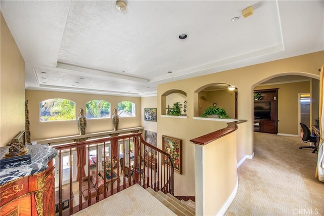 652 Fairway Dr, Redlands, CA 92373 - hall featuring a raised ceiling, an upstairs landing, carpet floors, baseboards, and arched walkways