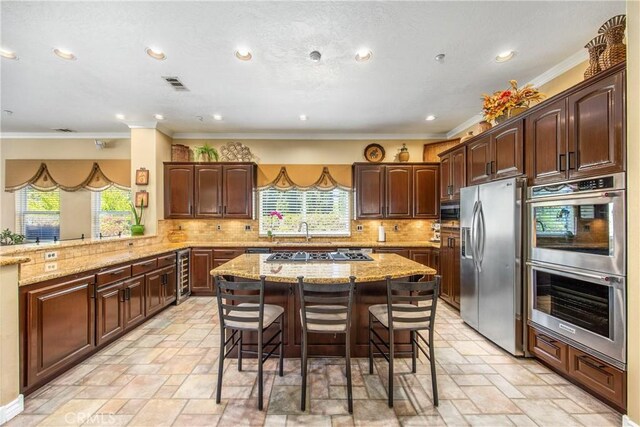 652 Fairway Dr, Redlands, CA 92373 - kitchen with appliances with stainless steel finishes, ornamental molding, a breakfast bar, stone tile flooring, and tasteful backsplash
