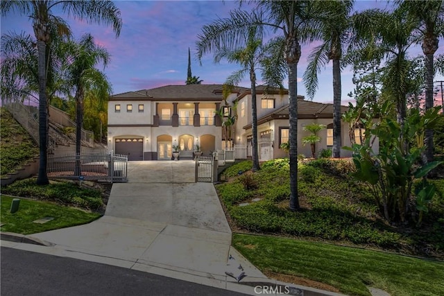 652 Fairway Dr, Redlands, CA 92373 - mediterranean / spanish-style home featuring concrete driveway, a gate, a fenced front yard, stucco siding, and an attached garage