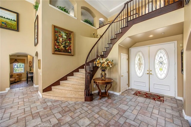 652 Fairway Dr, Redlands, CA 92373 - entrance foyer featuring a towering ceiling, arched walkways, baseboards, stairway, and french doors