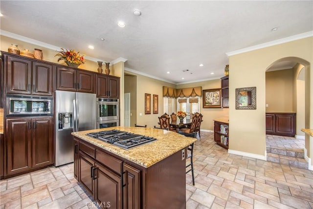 652 Fairway Dr, Redlands, CA 92373 - kitchen with stainless steel appliances, stone tile floors, arched walkways, a kitchen island, and recessed lighting