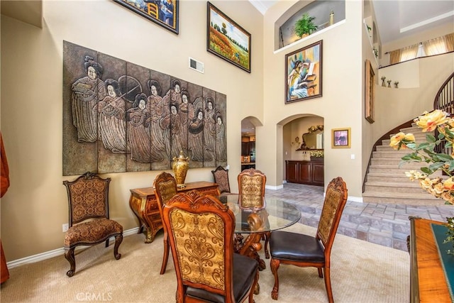 652 Fairway Dr, Redlands, CA 92373 - dining space with stairway, baseboards, a towering ceiling, and arched walkways