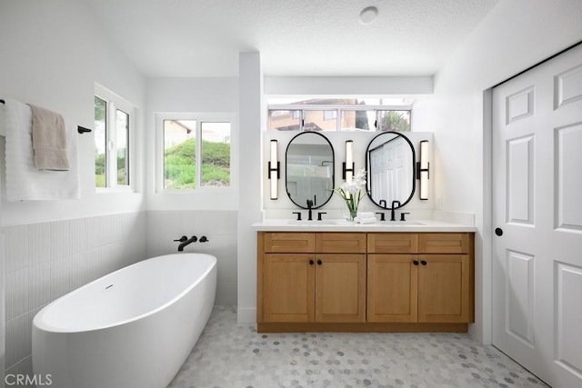 24411 Kings Vw, Laguna Niguel, CA 92677 - bathroom with double vanity, tile walls, a wainscoted wall, a freestanding bath, and a sink