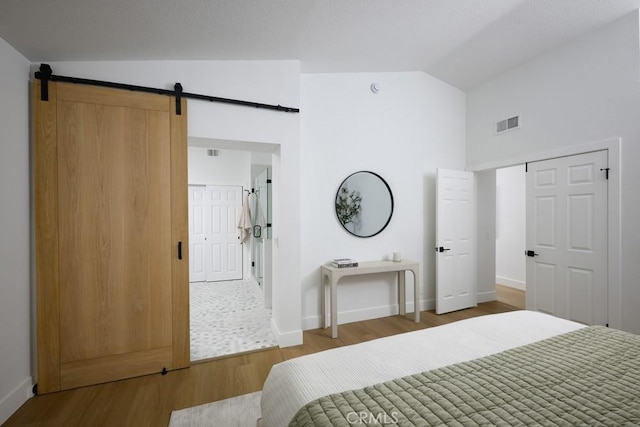 24411 Kings Vw, Laguna Niguel, CA 92677 - bedroom featuring wood finished floors, a barn door, and high vaulted ceiling