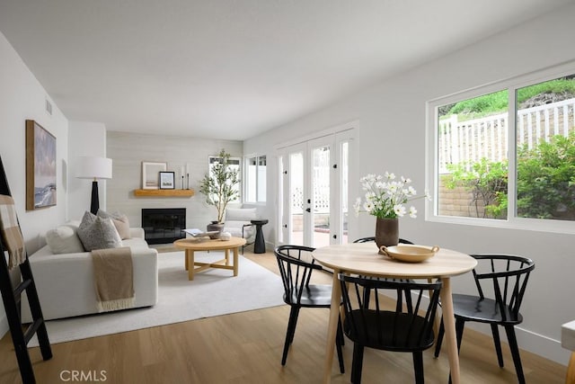 24411 Kings Vw, Laguna Niguel, CA 92677 - dining space with healthy amount of natural light, light wood-style floors, a glass covered fireplace, and french doors