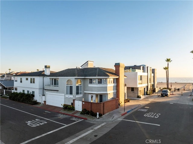 6711 Seashore Dr, Newport Beach, CA 92663 - view of front of property featuring uncovered parking, a water view, stucco siding, and a chimney