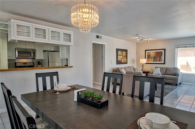 6711 Seashore Dr, Newport Beach, CA 92663 - dining area with light tile patterned floors, visible vents, a chandelier, and baseboards