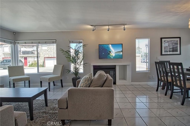 6711 Seashore Dr, Newport Beach, CA 92663 - living area with baseboards, light tile patterned floors, rail lighting, and a glass covered fireplace