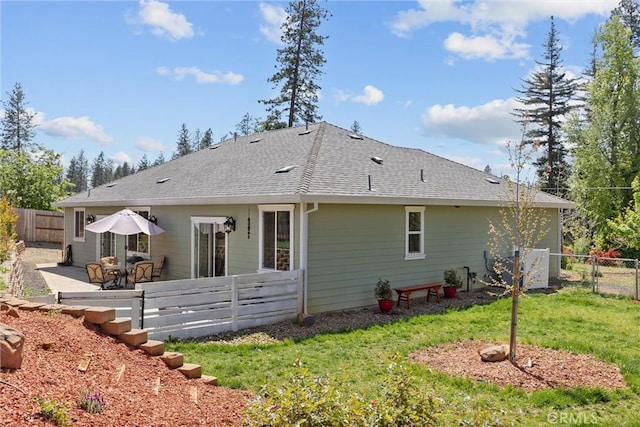 rear view of property with a patio, a fenced backyard, a shingled roof, and a lawn