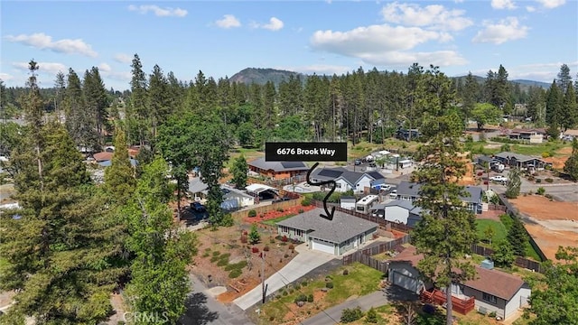 birds eye view of property featuring a residential view, a mountain view, and a wooded view