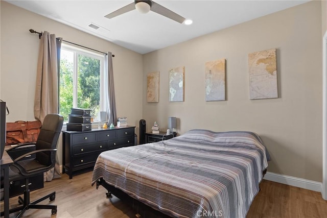 bedroom with visible vents, a ceiling fan, light wood-style flooring, and baseboards