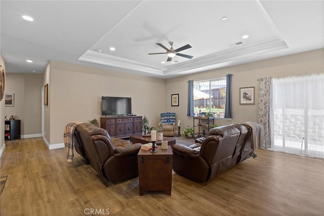 living room with visible vents, a tray ceiling, recessed lighting, wood finished floors, and a ceiling fan