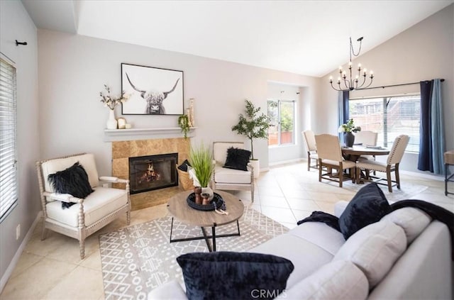 living room featuring lofted ceiling, light tile patterned floors, a chandelier, and baseboards