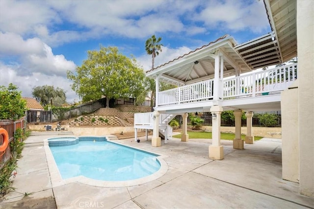 view of swimming pool featuring a pool with connected hot tub, stairway, a patio, and a fenced backyard