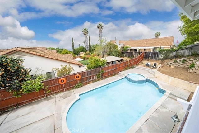 view of pool with a pool with connected hot tub, a fenced backyard, and a patio area