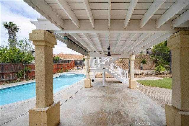 view of pool with a fenced backyard, a patio, a pool with connected hot tub, a ceiling fan, and stairs